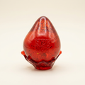 Red glitter toy resting on its splash base